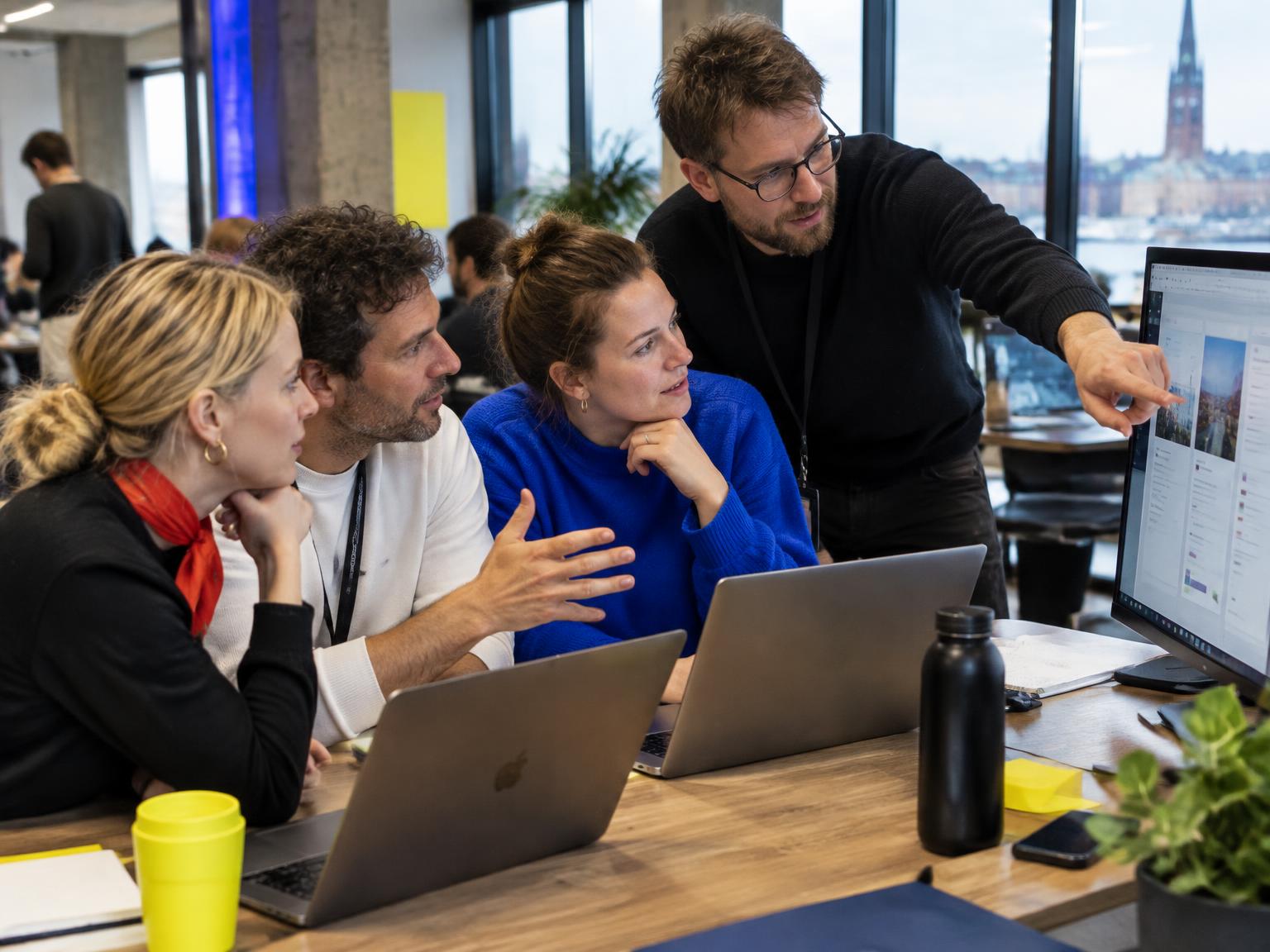 Participants collaborating around laptops and an AI-assisted prototype at a Riga workshop